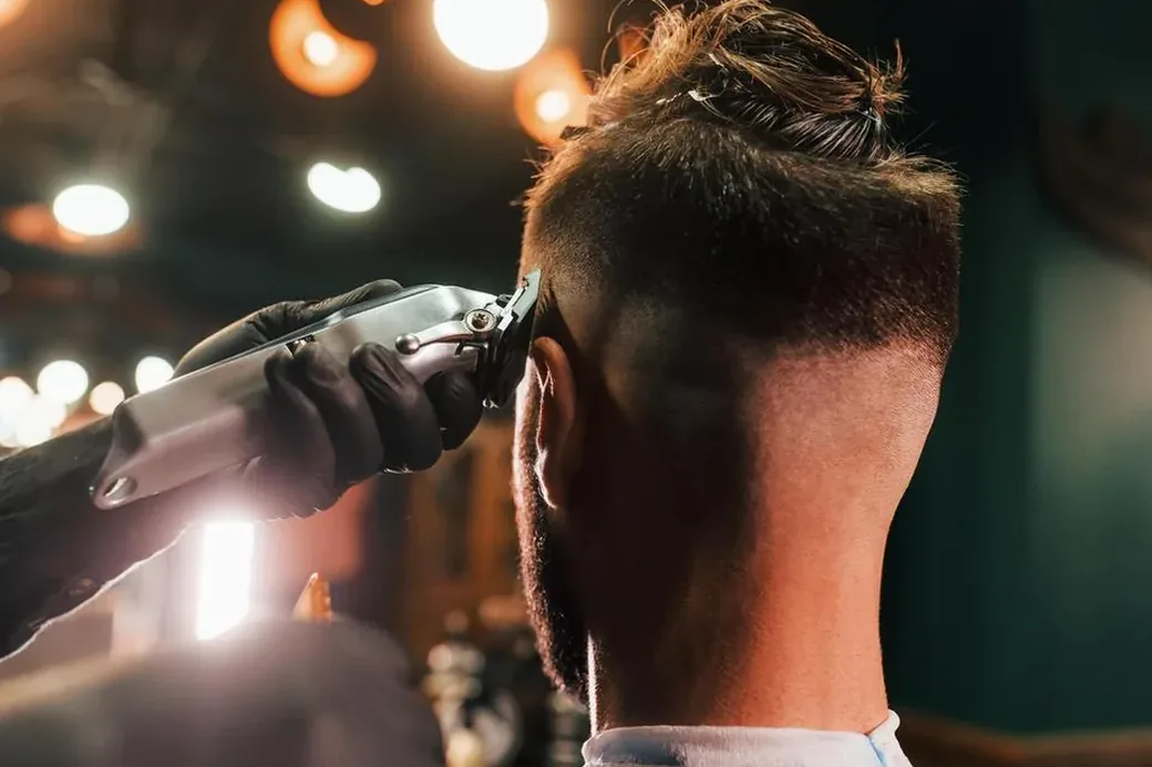 Barber blending a skin fade with a cordless clipper